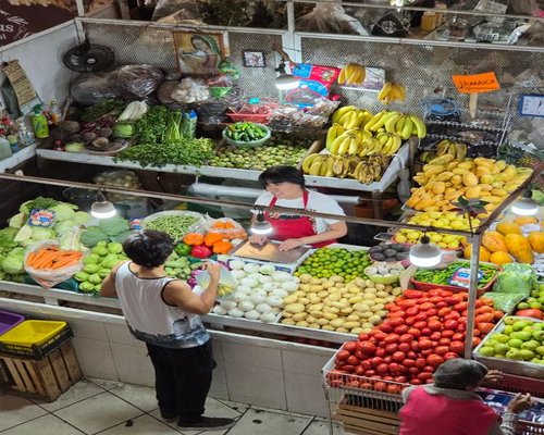 Colorful display of fresh avocados, tomatoes, and mangos at a local Mexican market